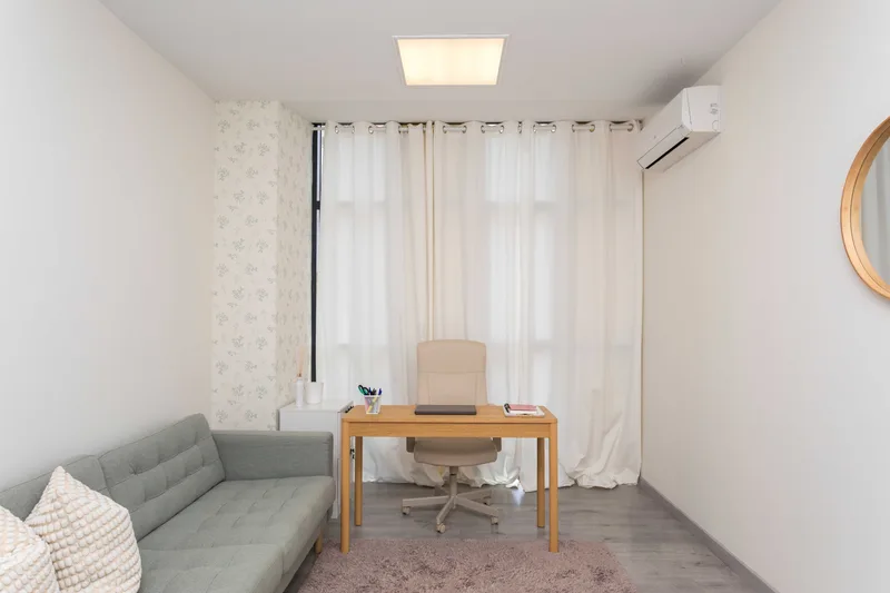 Consulta con sofá y escritorio junto a la ventana