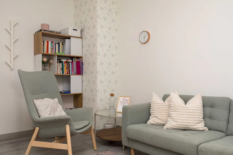 Rincón de lectura, con sillón, estantería de libros y sofá